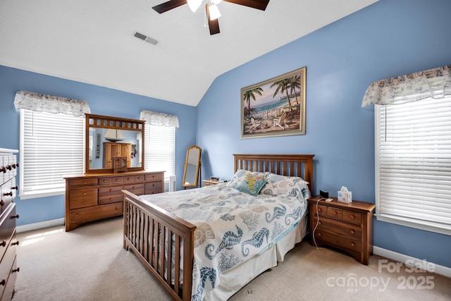 bedroom with light carpet, vaulted ceiling, baseboards, and a ceiling fan