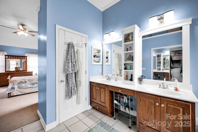 full bath featuring connected bathroom, a ceiling fan, tile patterned flooring, double vanity, and crown molding