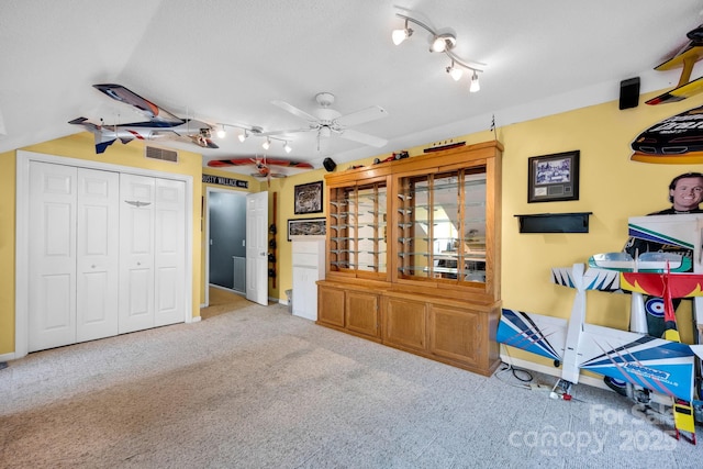 rec room featuring carpet flooring, a ceiling fan, baseboards, and track lighting