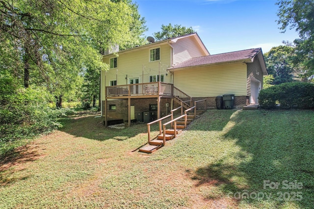 back of house featuring a lawn, an attached garage, stairs, and a deck