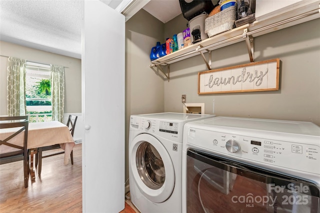 laundry area featuring laundry area, washer and clothes dryer, and light wood-style flooring
