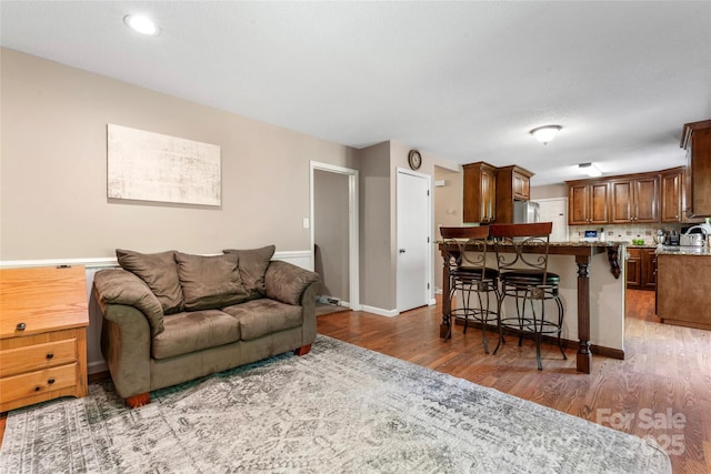 living area featuring baseboards and wood finished floors