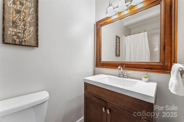 full bath with vanity, baseboards, and toilet