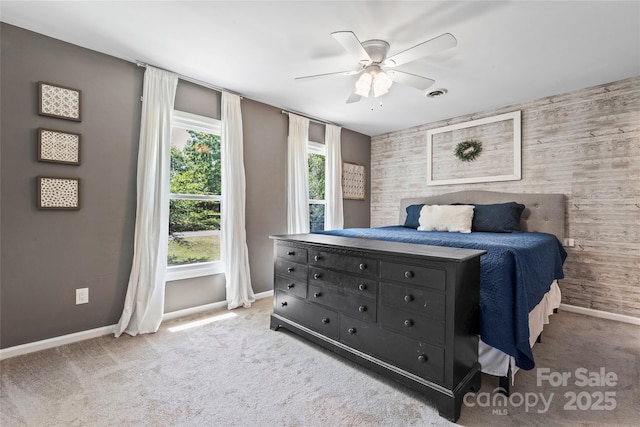 bedroom featuring baseboards, a ceiling fan, carpet, and an accent wall