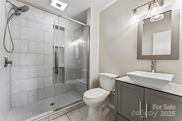 bathroom featuring a stall shower, toilet, marble finish floor, and vanity