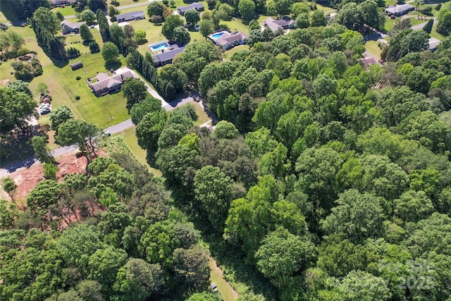birds eye view of property featuring a wooded view
