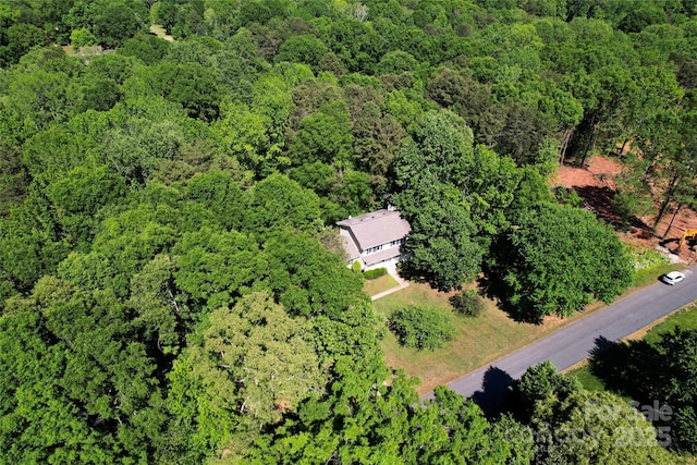 drone / aerial view featuring a wooded view