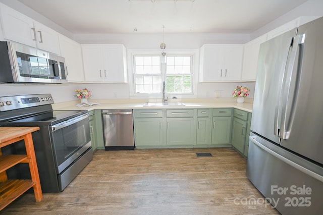 kitchen featuring a sink, white cabinetry, appliances with stainless steel finishes, and green cabinets