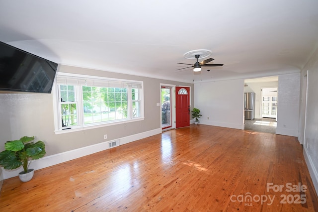 unfurnished living room featuring ceiling fan, visible vents, and wood finished floors