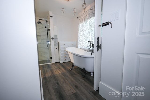 full bathroom with a freestanding tub, a shower stall, and wood finished floors