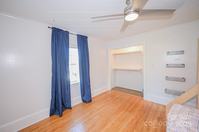 unfurnished bedroom with baseboards, ornamental molding, and light wood-style flooring