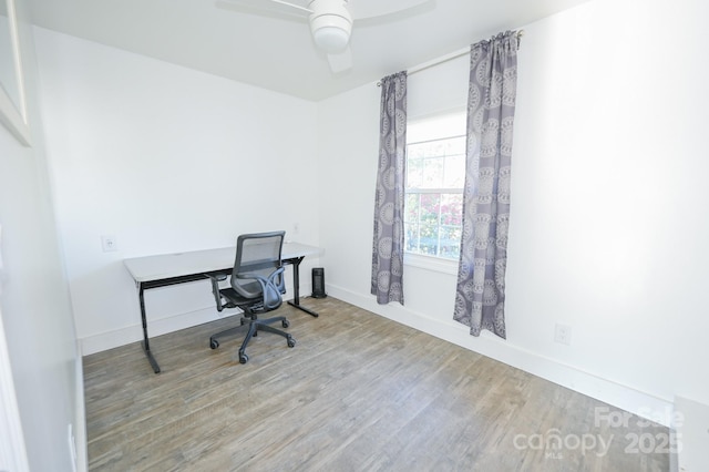 office area featuring a ceiling fan, baseboards, and wood finished floors
