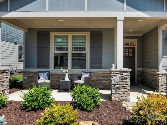 entrance to property featuring covered porch and stone siding