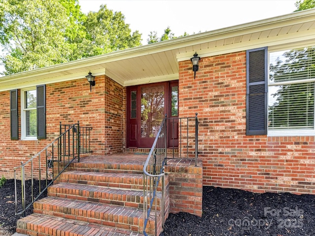 view of exterior entry with brick siding