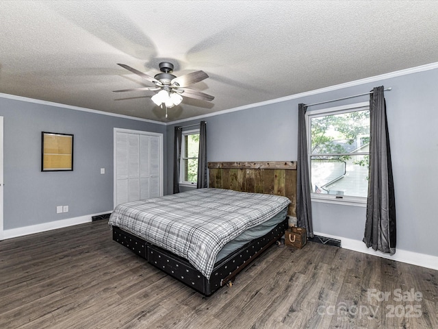 bedroom featuring wood finished floors, a textured ceiling, ornamental molding, a closet, and baseboards