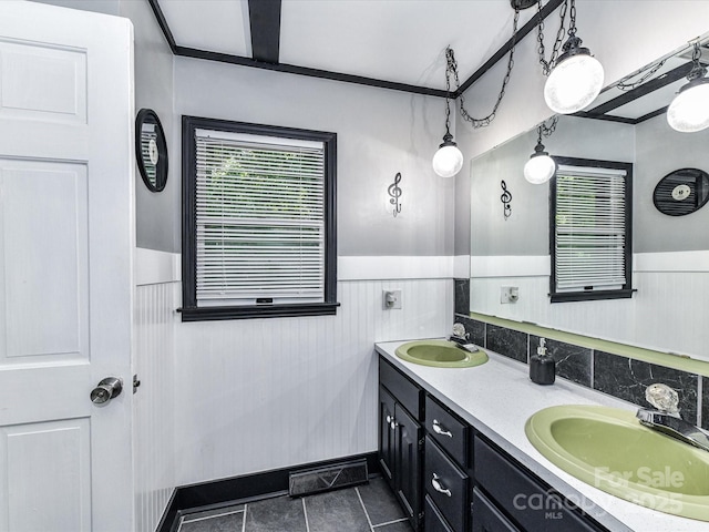 full bath with wainscoting, double vanity, and tile patterned flooring