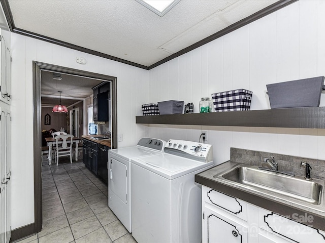 laundry area with washer and clothes dryer, crown molding, a textured ceiling, cabinet space, and light tile patterned floors