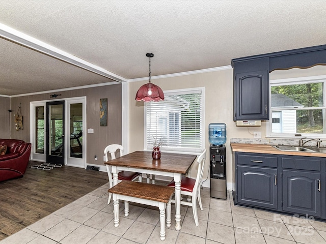 70 Cumberland Ct SW, Concord, NC 28025 - dining space featuring ornamental molding, a textured ceiling, light tile patterned flooring, plenty of natural light, and baseboards