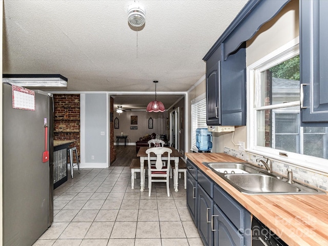 70 Cumberland Ct SW, Concord, NC 28025 - kitchen featuring a sink, butcher block countertops, light tile patterned flooring, a textured ceiling, and hanging light fixtures