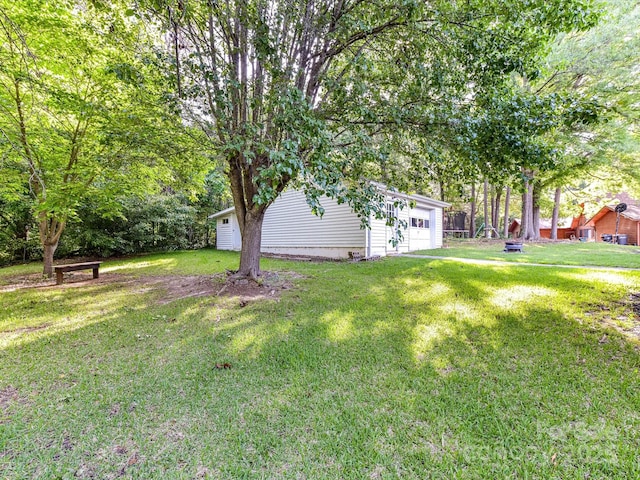 70 Cumberland Ct SW, Concord, NC 28025 - view of grassy yard with an outdoor structure and a garage
