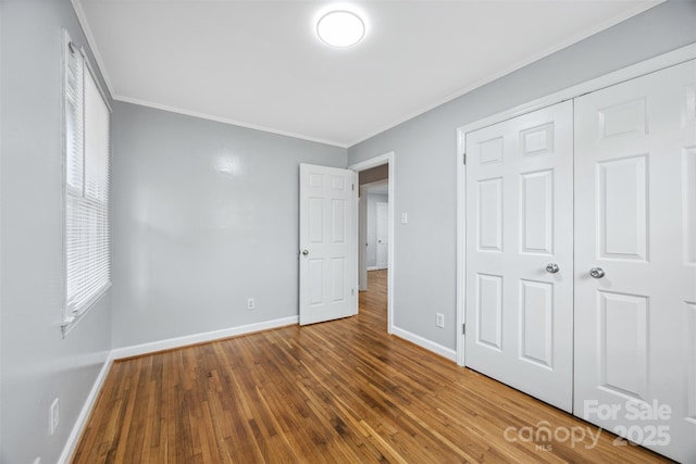 3828 Delgany Dr, Charlotte, NC 28215 - unfurnished bedroom with ornamental molding, baseboards, hardwood / wood-style floors, and a closet