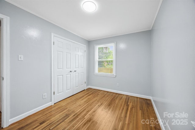 3828 Delgany Dr, Charlotte, NC 28215 - unfurnished bedroom featuring ornamental molding, hardwood / wood-style flooring, baseboards, and a closet
