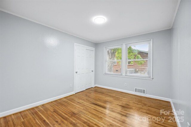 3828 Delgany Dr, Charlotte, NC 28215 - unfurnished room with crown molding, baseboards, and light wood-style flooring