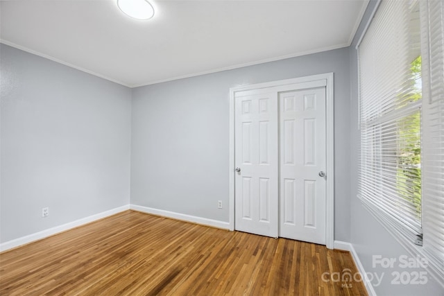 3828 Delgany Dr, Charlotte, NC 28215 - unfurnished bedroom with baseboards, wood finished floors, crown molding, and a closet