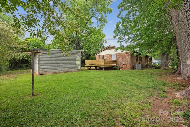 3828 Delgany Dr, Charlotte, NC 28215 - view of grassy yard with an outbuilding, central AC, a storage unit, and a wooden deck