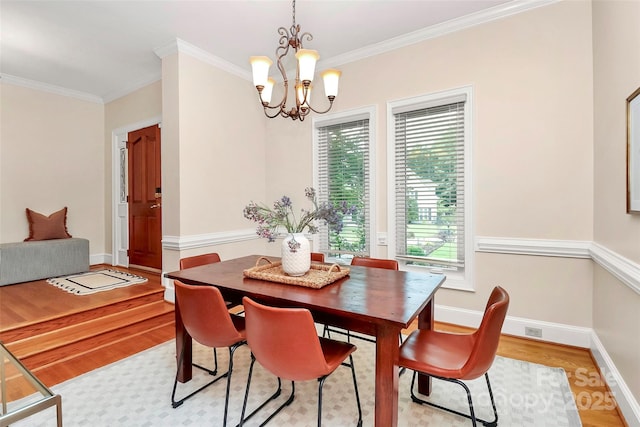 4509 Rosecliff Dr, Charlotte, NC 28277 - dining space with light wood-style flooring, a chandelier, ornamental molding, and baseboards