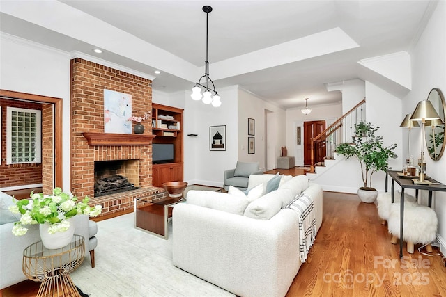 4509 Rosecliff Dr, Charlotte, NC 28277 - living area featuring wood finished floors, crown molding, stairs, a brick fireplace, and baseboards
