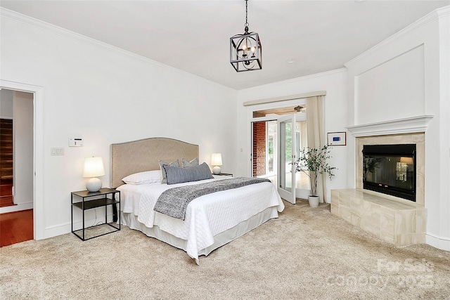 4509 Rosecliff Dr, Charlotte, NC 28277 - bedroom with access to exterior, carpet, crown molding, a chandelier, and a glass covered fireplace