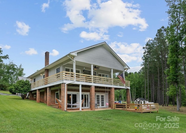 back of house with french doors, a lawn, a wooden deck, and a ceiling fan