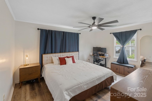 bedroom featuring wood finished floors, ornamental molding, baseboards, and ceiling fan