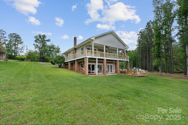back of house with a wooden deck, a chimney, a lawn, and french doors