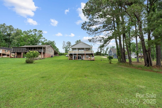 view of green lawn featuring a wooden deck