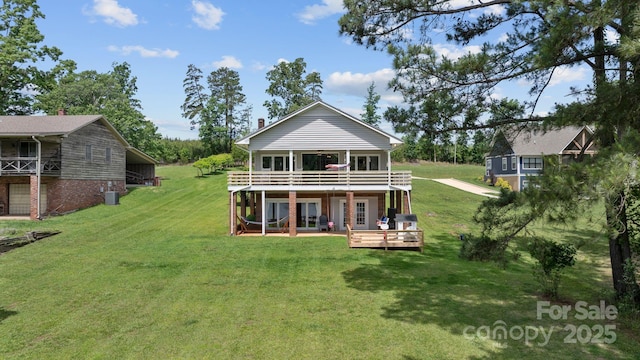 back of property with a deck and a lawn