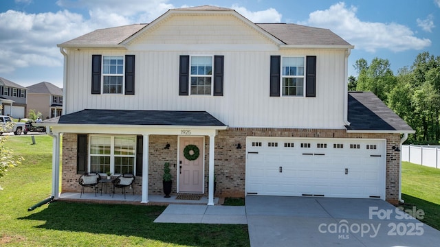 traditional-style house with covered porch, driveway, a front yard, a garage, and brick siding