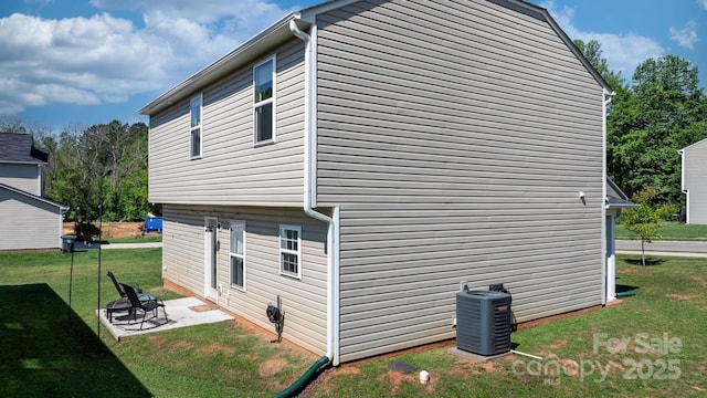 view of side of property with a patio, central AC, and a yard