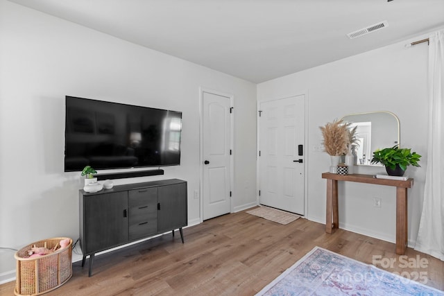foyer featuring visible vents, baseboards, and wood finished floors