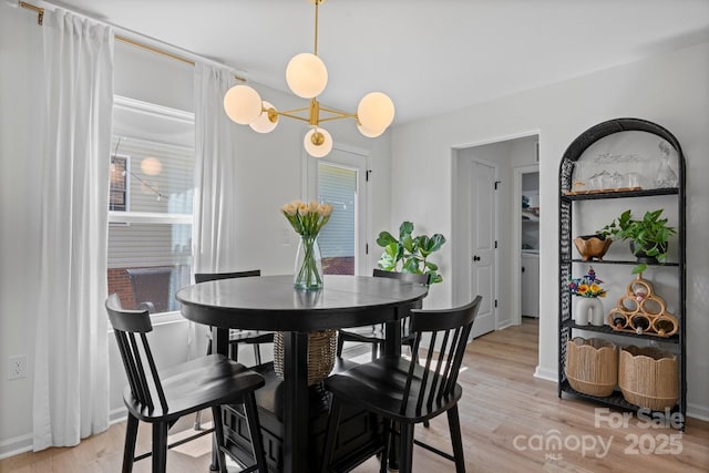 dining space featuring baseboards and light wood-style flooring