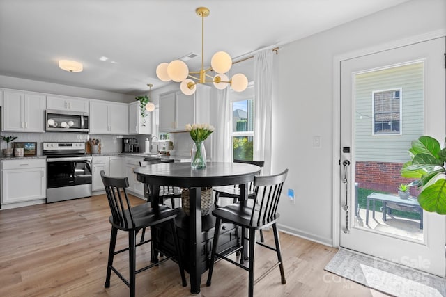 dining room featuring an inviting chandelier and light wood-style floors