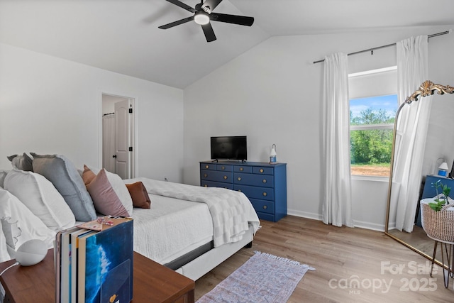 bedroom featuring light wood-style floors, baseboards, ceiling fan, and vaulted ceiling