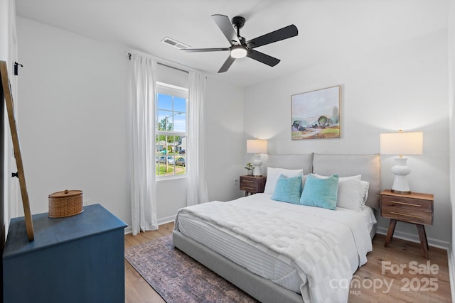 bedroom with light wood-style floors, baseboards, a ceiling fan, and visible vents