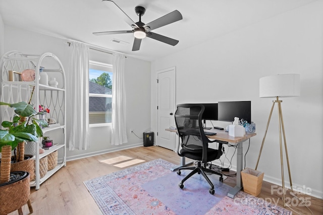 office featuring baseboards, ceiling fan, wood finished floors, and visible vents