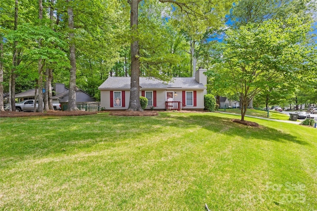 view of front of home with a chimney and a front lawn