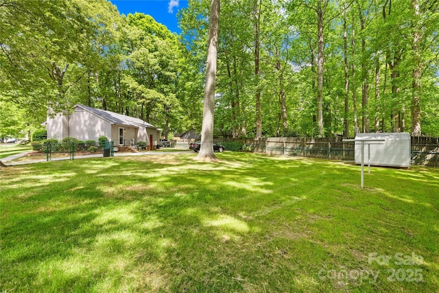 view of yard featuring an outbuilding, a shed, and a fenced backyard