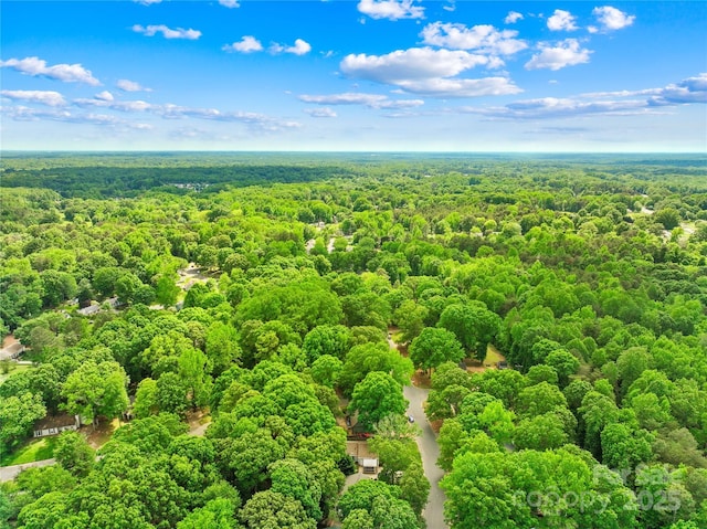 drone / aerial view featuring a wooded view