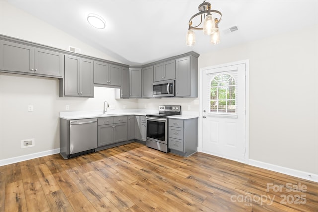 kitchen with visible vents, gray cabinetry, a sink, an inviting chandelier, and stainless steel appliances