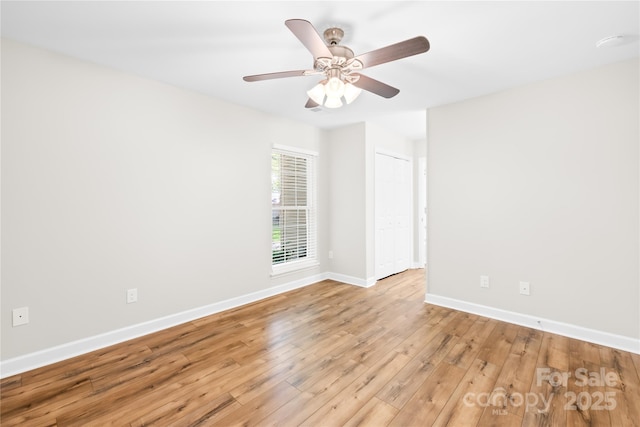 spare room featuring a ceiling fan, baseboards, and light wood-style floors